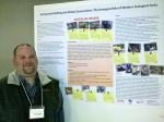Charles Snyder from Washington State University stands by his poster "Community Building and Global Conservation: The Emergent Role of Modern Zoological Parks". Photo by Trainor.