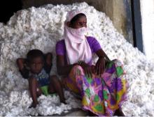 A cotton worker and her son rest in between packing cotton into a gin on the outskirts of Warangal, Telangana.